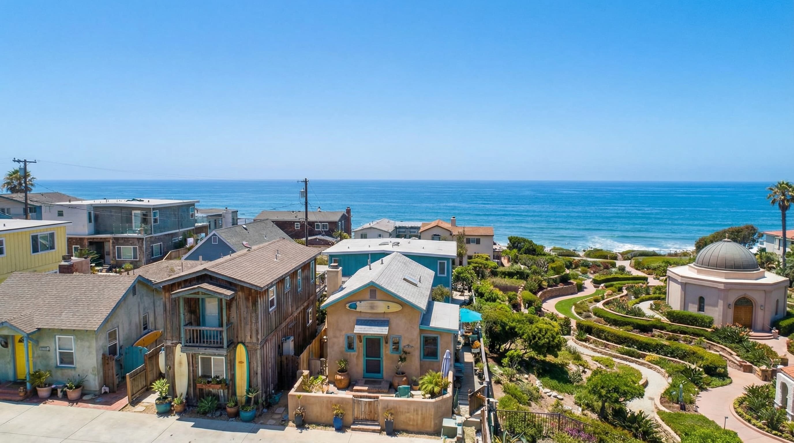 Laid-back Encinitas California surf town with eclectic beach cottages and homes, Self-Realization Fellowship gardens visible, and Pacific Ocean in background